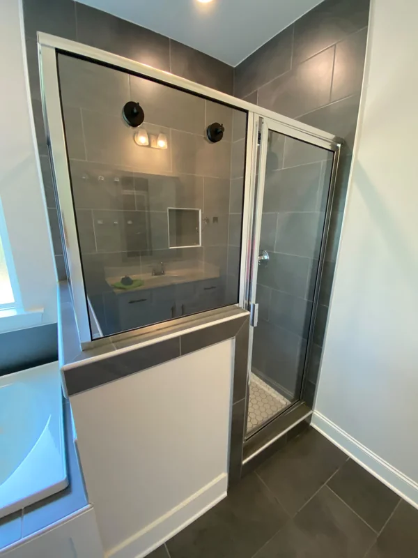 A glass shower enclosure with clean tile and fixtures